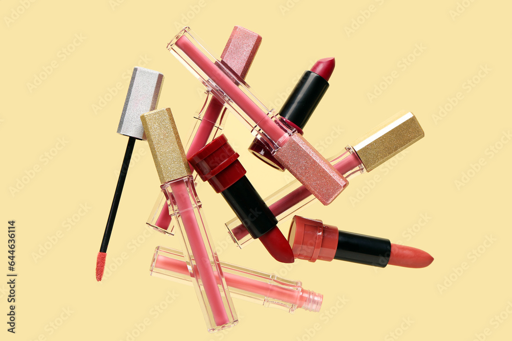 Beautiful lipsticks flying against color background