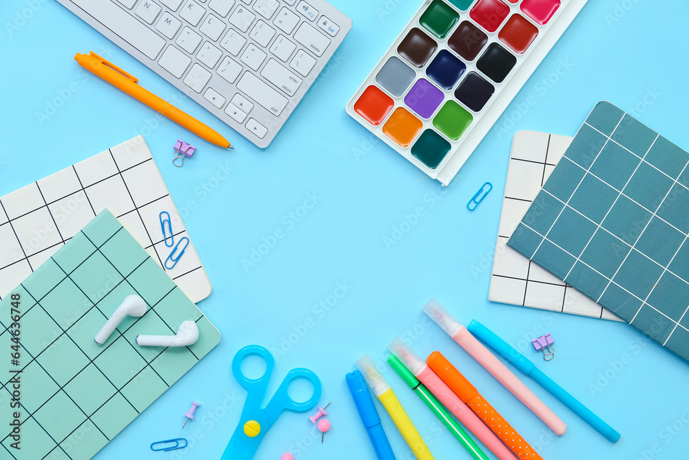 Frame made of different stationery, keyboard and earphones on color background