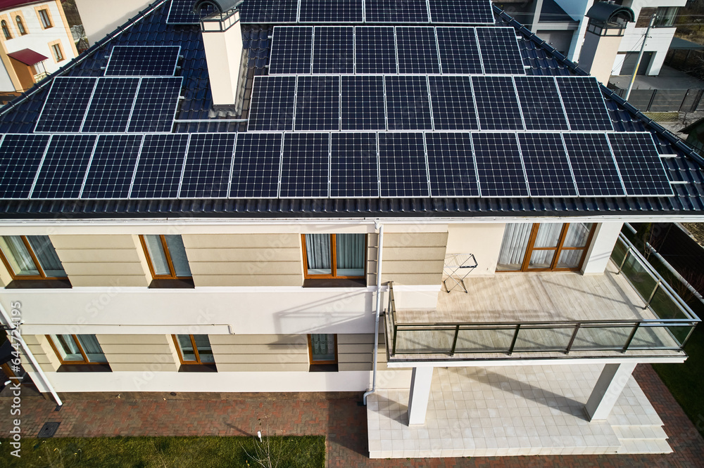 Residential house with solar modules for generating electricity through photovoltaic effect. Aerial 