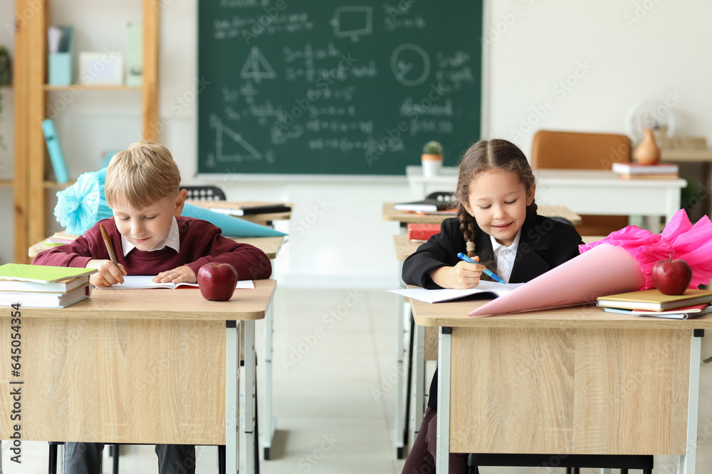 Classmates with school cones sitting at desks in classroom