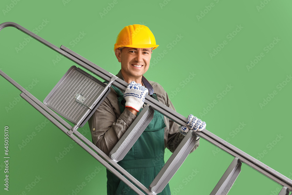 Mature builder with stepladder on green background