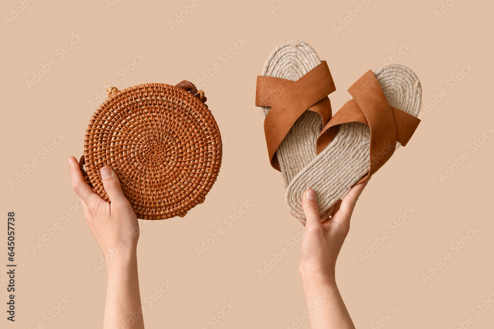 Female hands with beach accessories on beige background