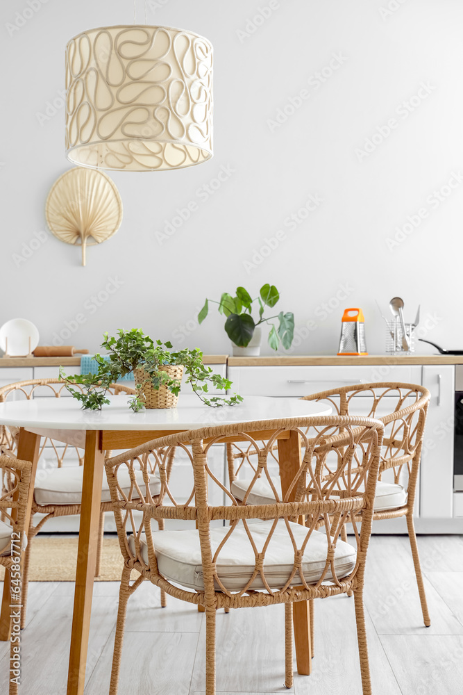 Interior of light kitchen with dining table and white counters