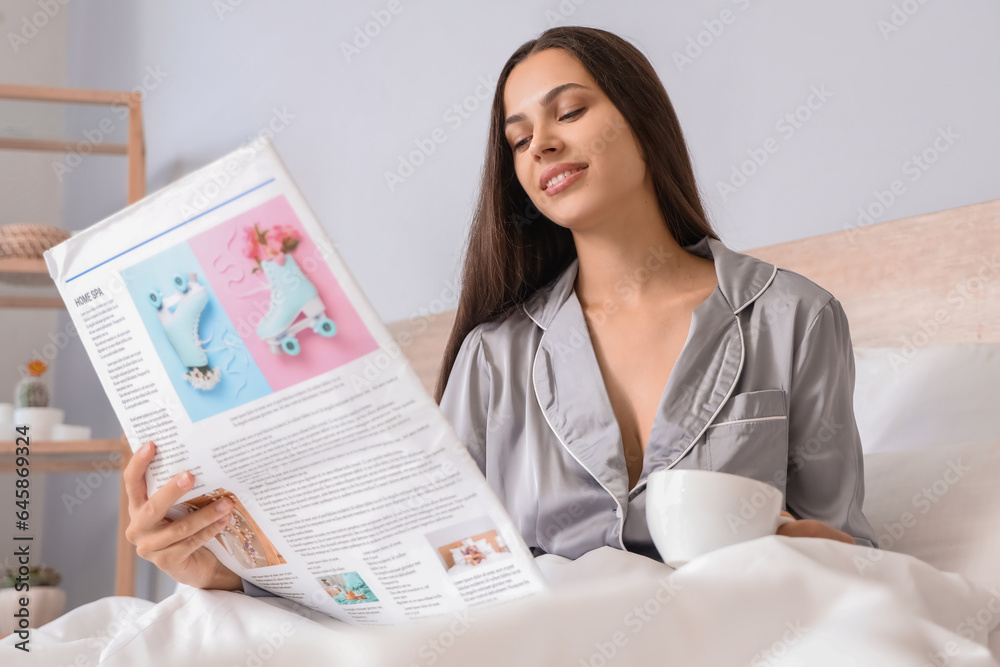 Morning of beautiful woman drinking coffee and reading newspaper in bed