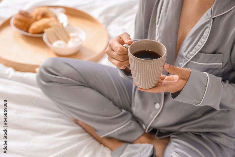 Morning of pretty young woman having tasty breakfast in bed