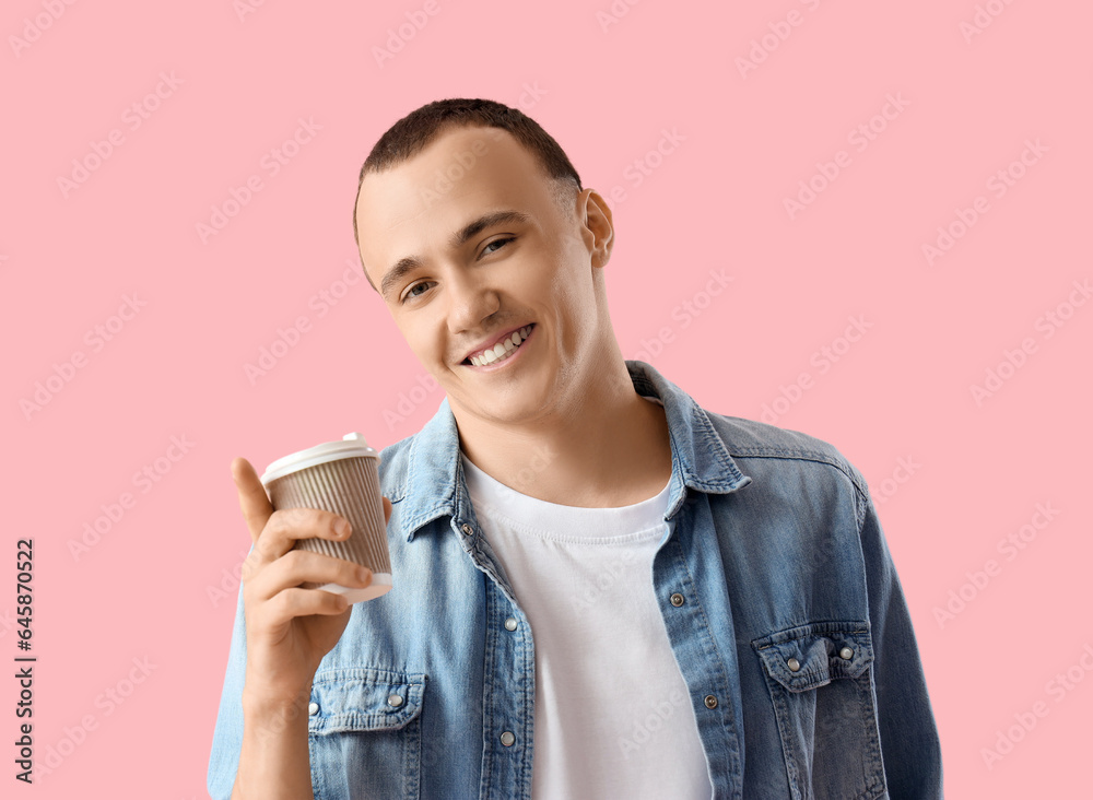 Young man with cup of coffee on pink background, closeup