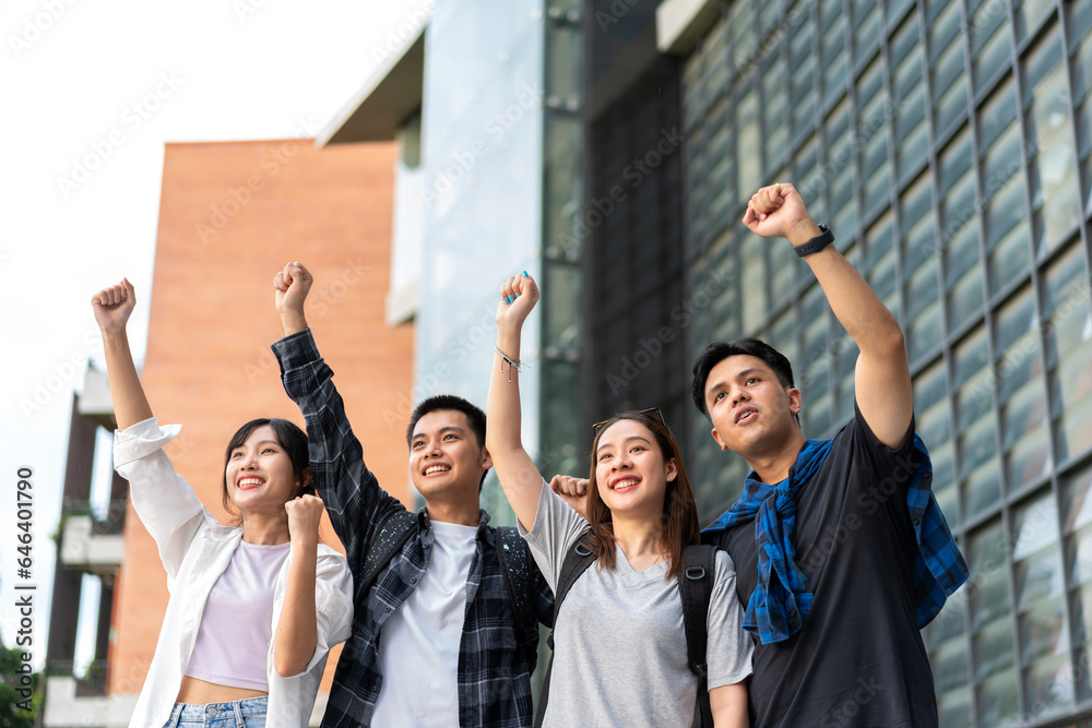 Group of happy young entrepreneurs with hands up and laughing to celebrate and excited success for a