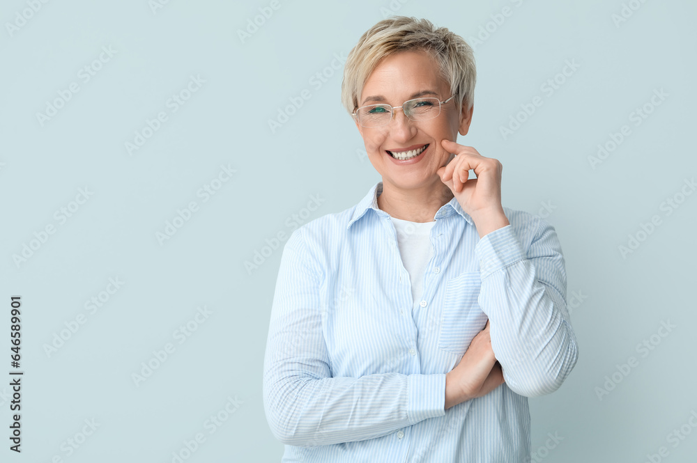 Mature woman in eyeglasses on light background