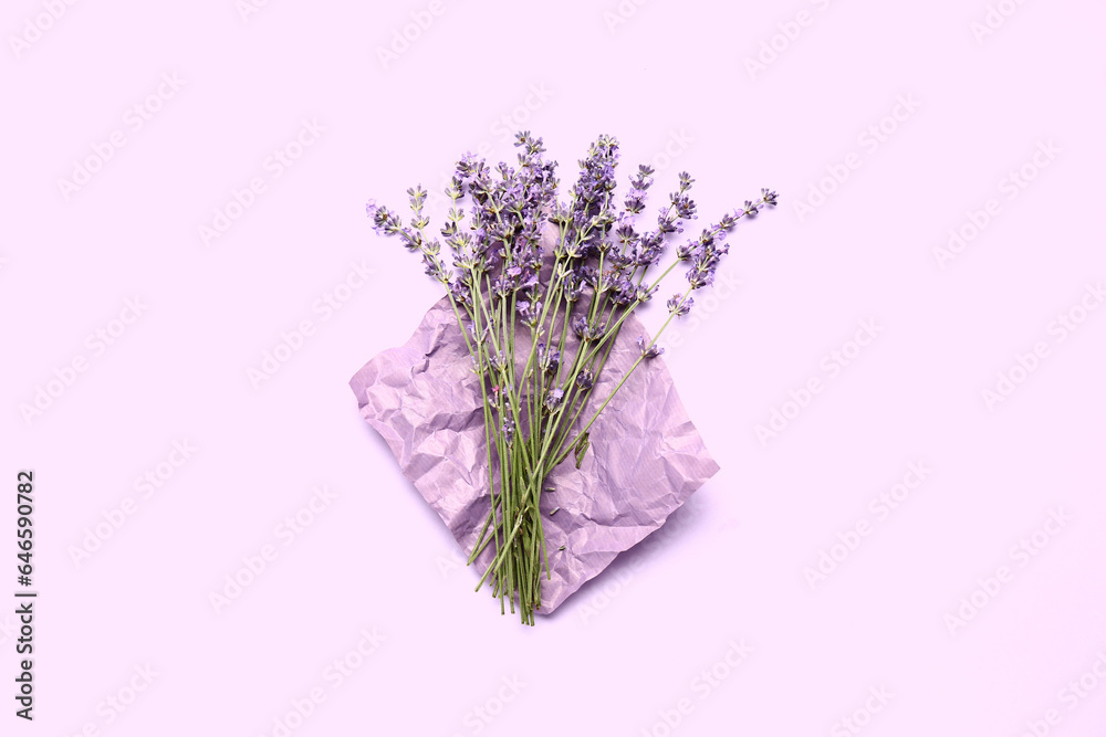 Crumpled paper with beautiful lavender flowers on purple background