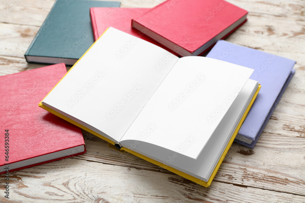 Open book with blank pages on white wooden table