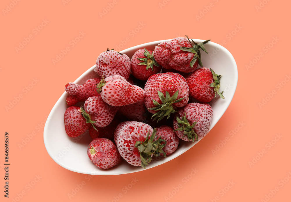 Bowl of frozen strawberry on color background