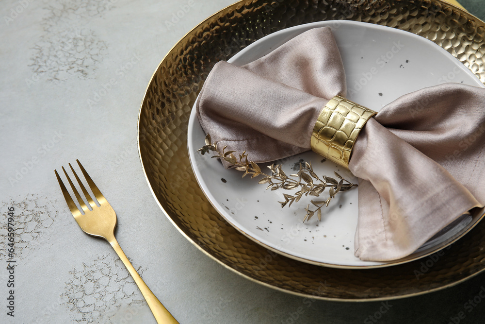 Elegant table setting with golden leaves and fork on grey table, closeup