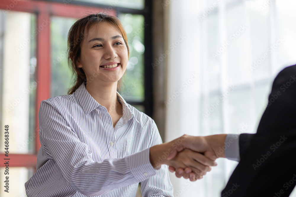 Businesswoman shaking hands with financial advisor at meeting in office.