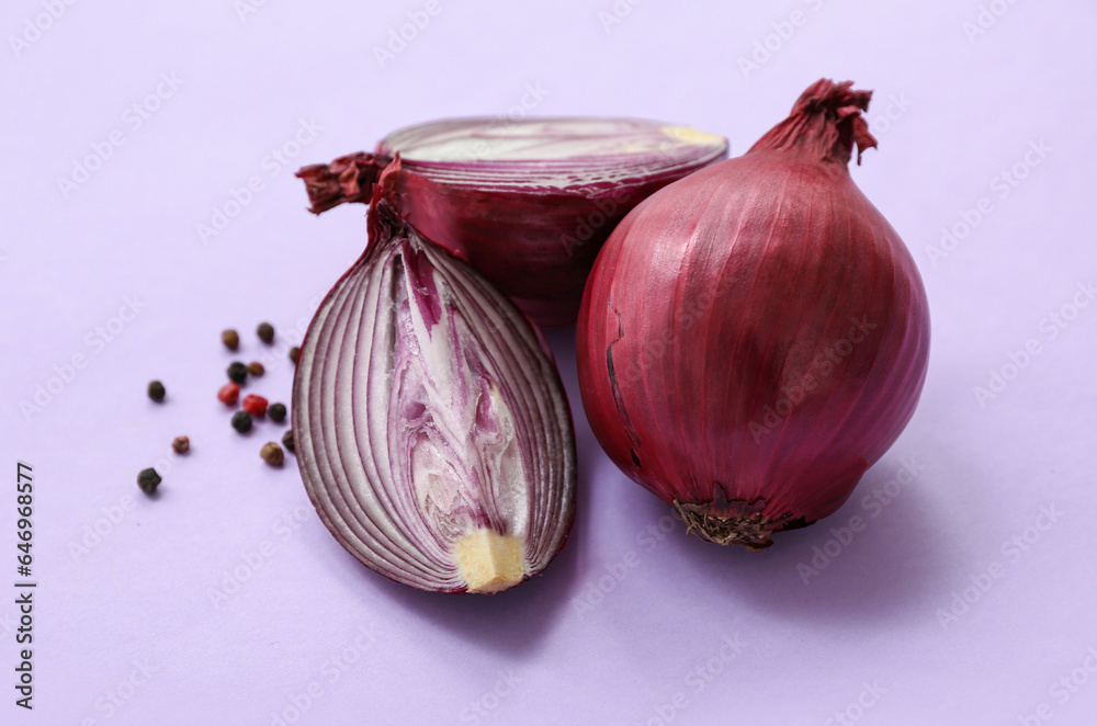 Fresh red onions and peppercorn on lilac background