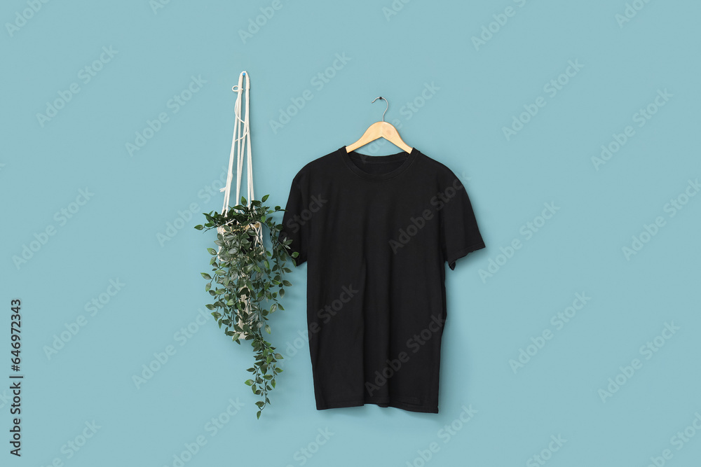 Stylish black t-shirt hanging on blue background