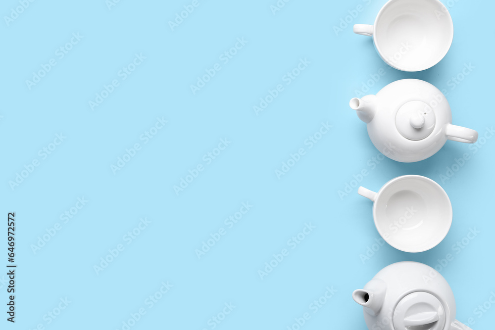 Teapots and cups on color background