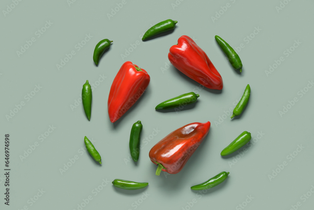 Different fresh peppers on green background