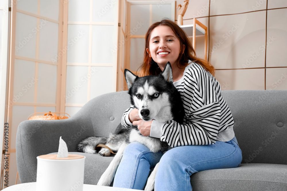 Happy young woman with husky dog at home