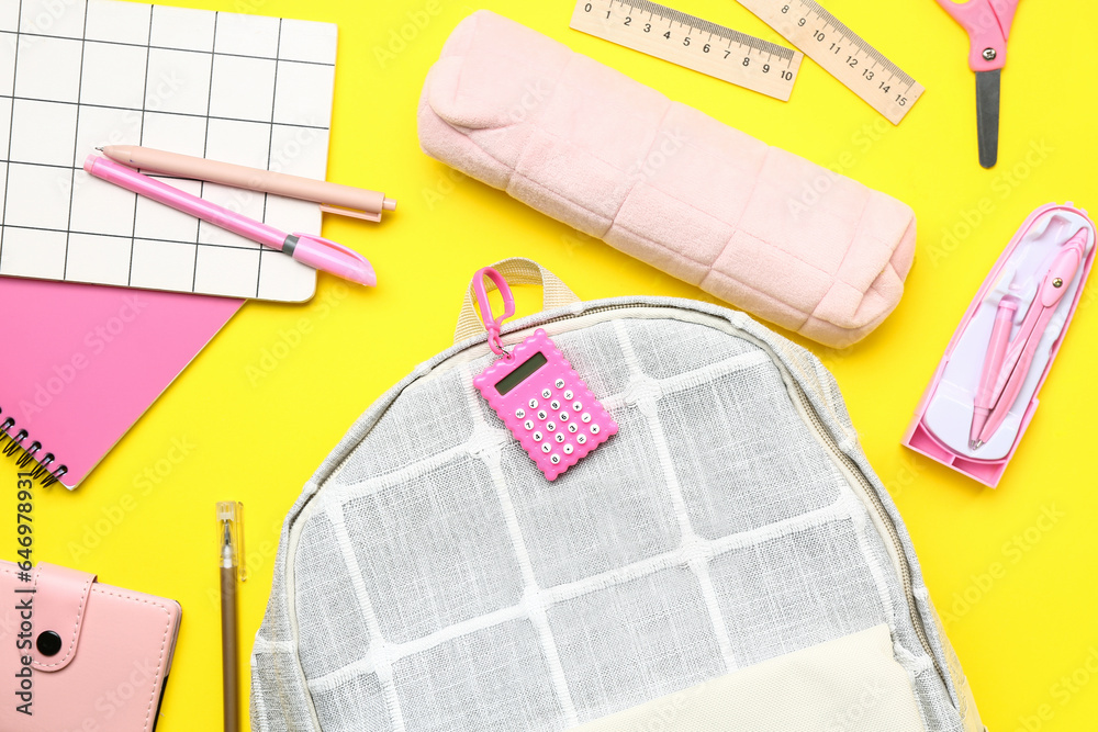 Stylish school backpack with different stationery supplies on yellow background