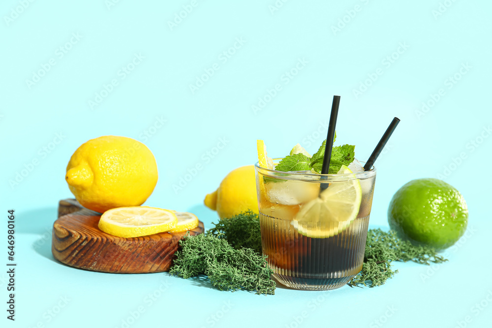 Glass of cold Long Island iced tea on light blue background