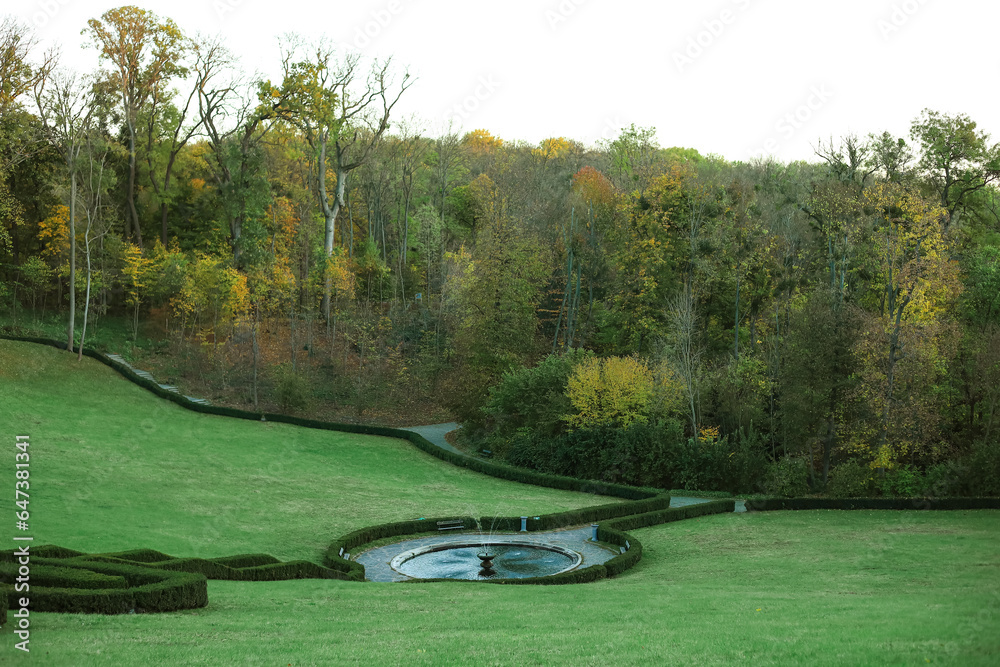 View of beautiful autumn park with fountain and trees