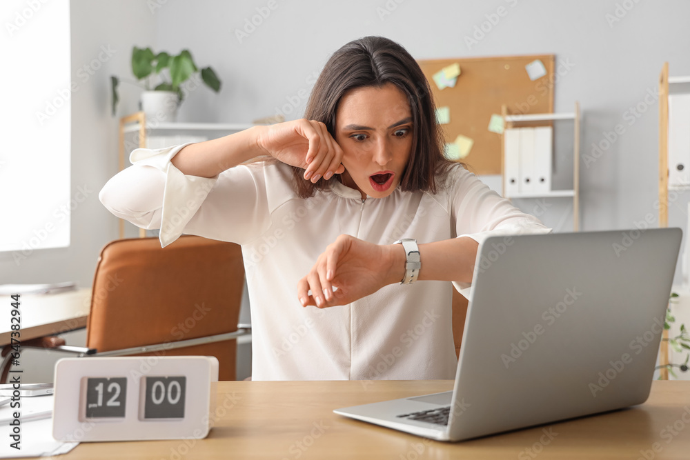 Stressed young businesswoman working under deadline in office