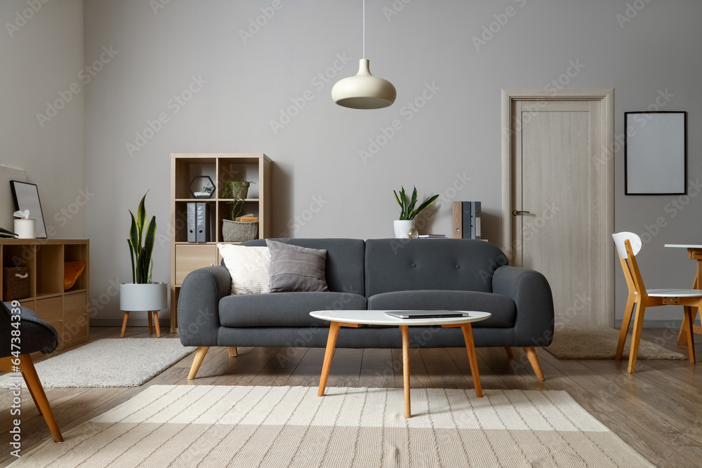 Interior of modern living room with sofa and laptop on table