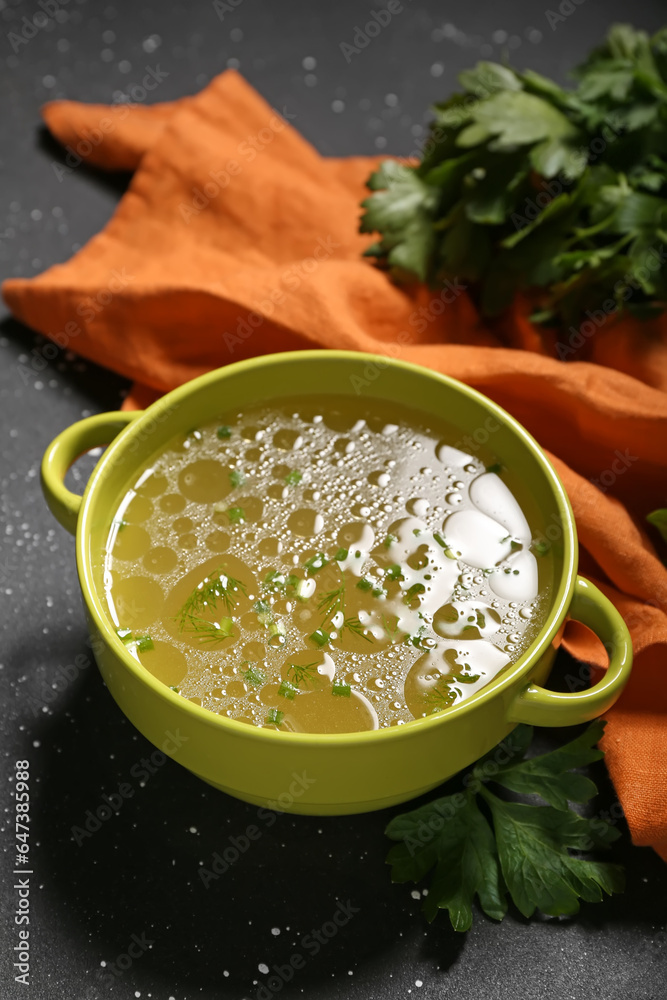 Pot of tasty vegetable broth on black background