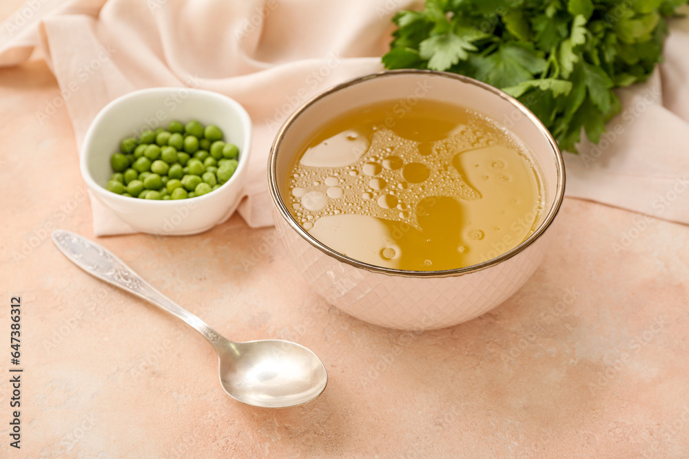 Bowl of tasty vegetable broth on beige background