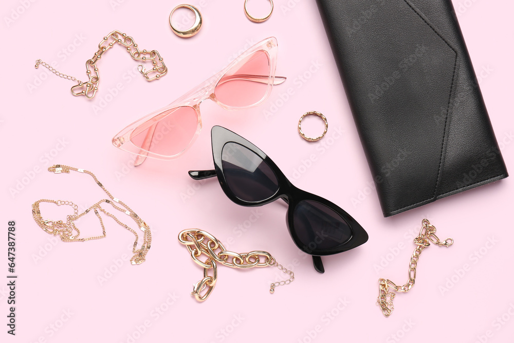 Stylish sunglasses with beautiful jewellery on pink background