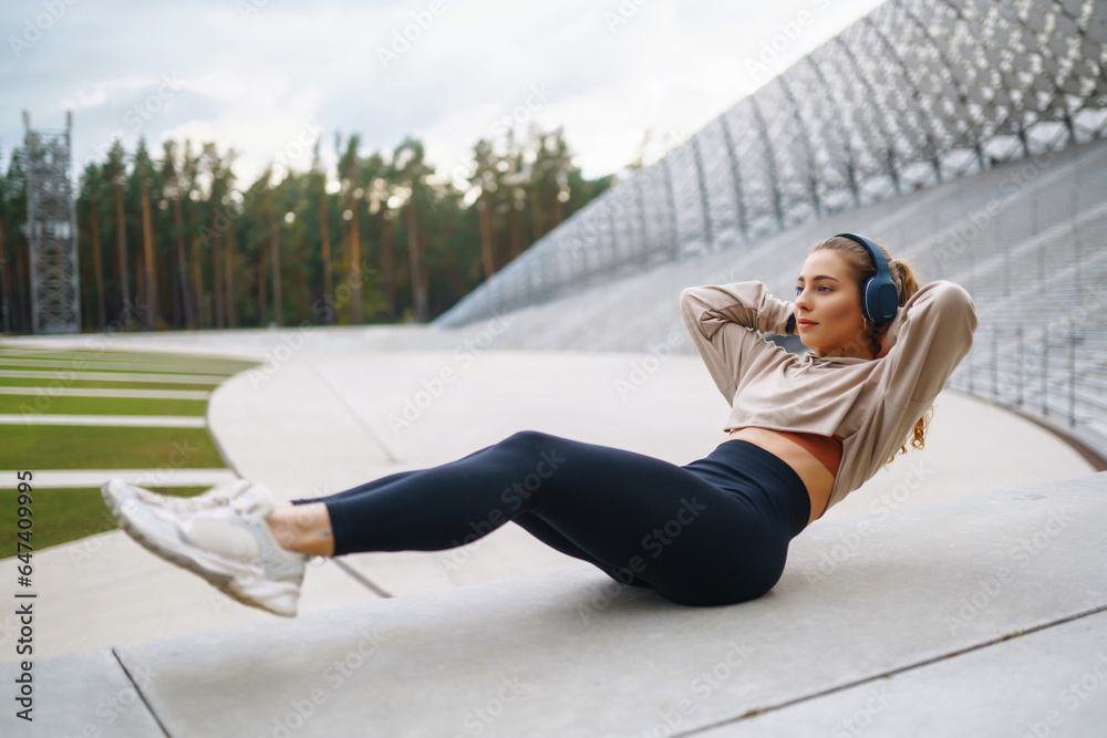 Sportswoman doing exercises on the street. A woman in sportswear goes in for sports, does exercises 