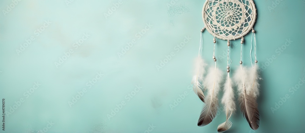 Dream catcher with lace design on textured turquoise background resembling concrete