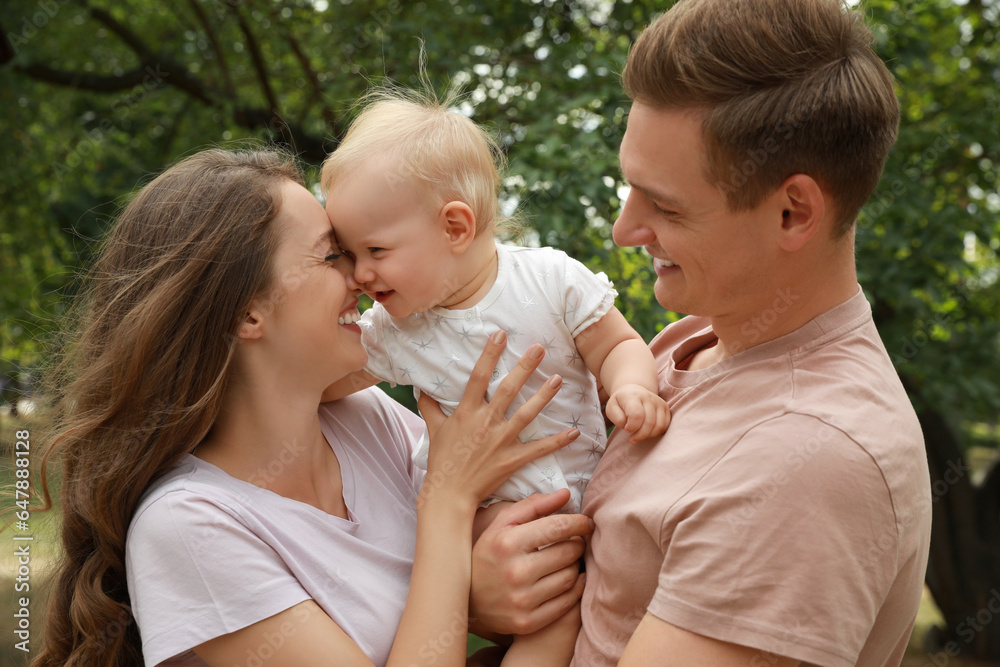 Parents with their cute baby spending time together outdoors. Happy family