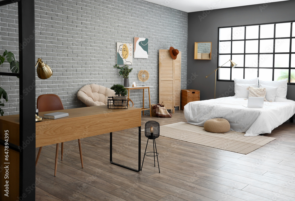 Interior of modern bedroom with bed and workplace