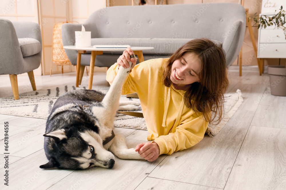 Happy young woman with husky dog at home