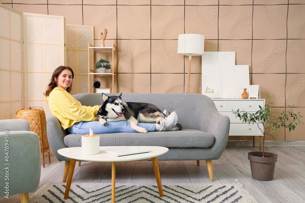 Happy young woman with husky dog at home