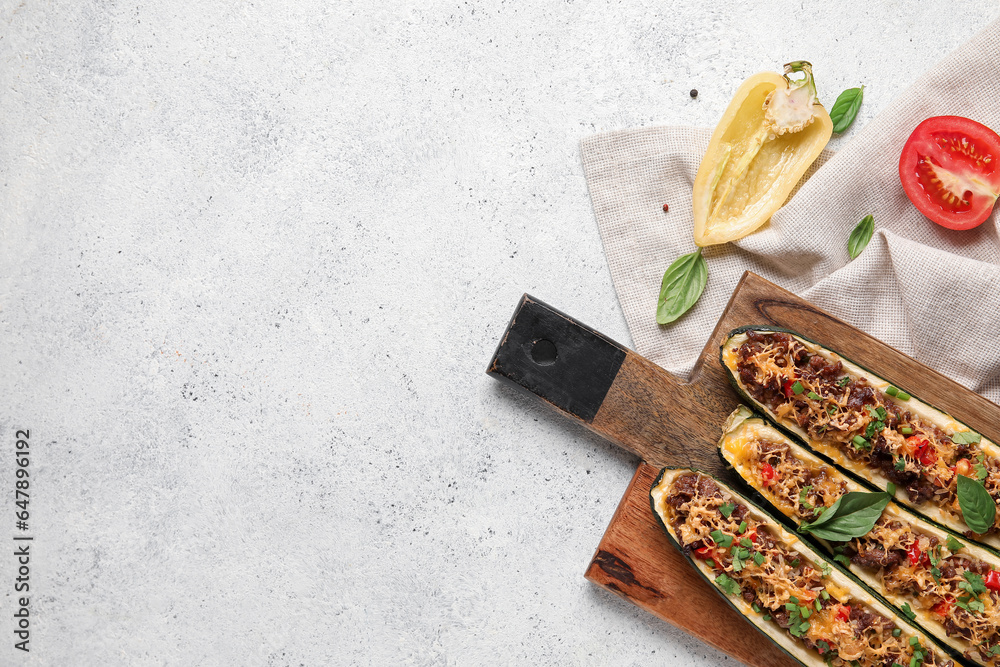 Wooden board with meat stuffed zucchini boats on white background