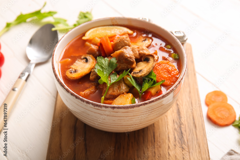 Bowl of tasty beef stew on white background