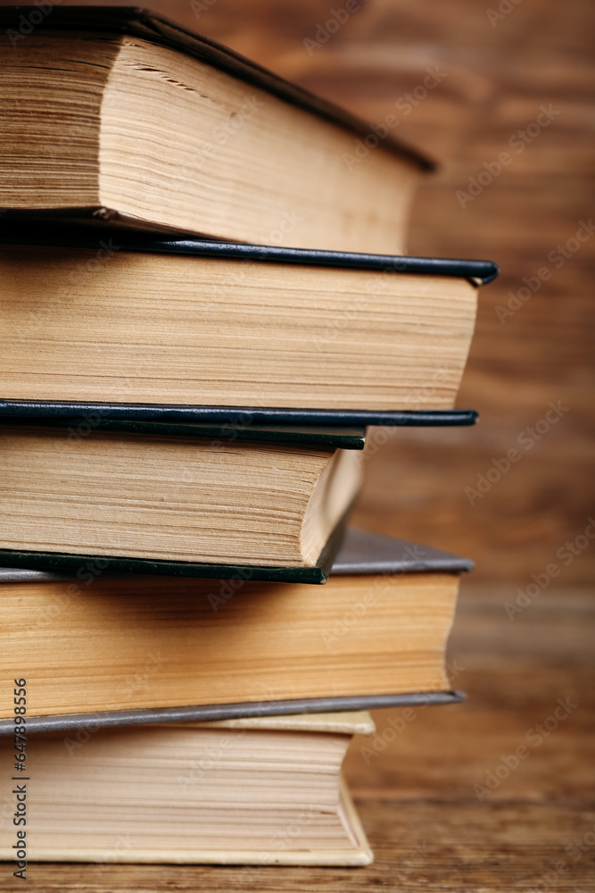 Stack of old hardcover books on wooden background, closeup