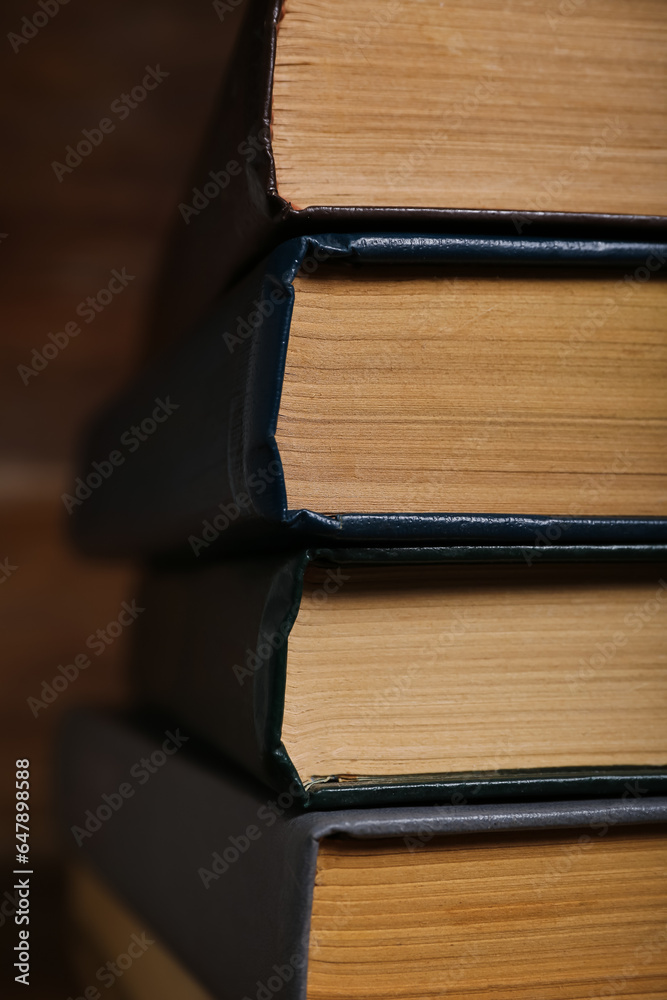 Stack of old hardcover books on wooden background, closeup