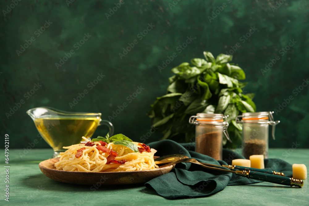 Plate with tasty pasta carbonara on green background