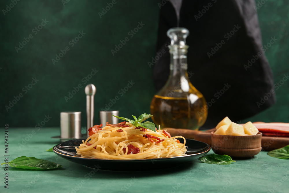 Plate with tasty pasta carbonara on green background