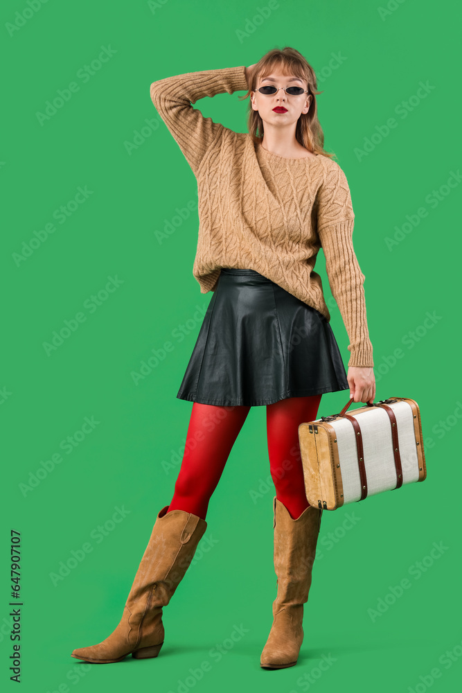 Stylish young woman in fall clothes on green background