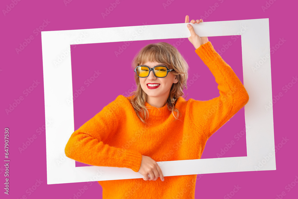 Young woman with frame on purple background