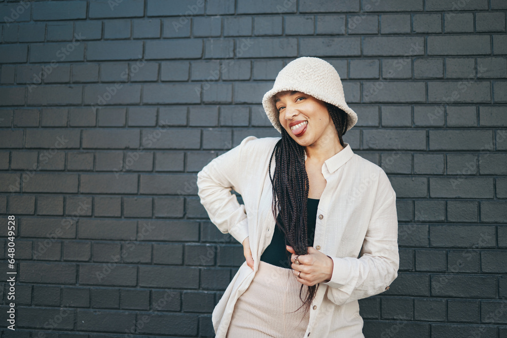 Fashion, happy and portrait of woman in city with trendy outfit, cool clothes and style for glamour. Beauty, smile and person on gray wall background with confidence, pride and cosmetics in town