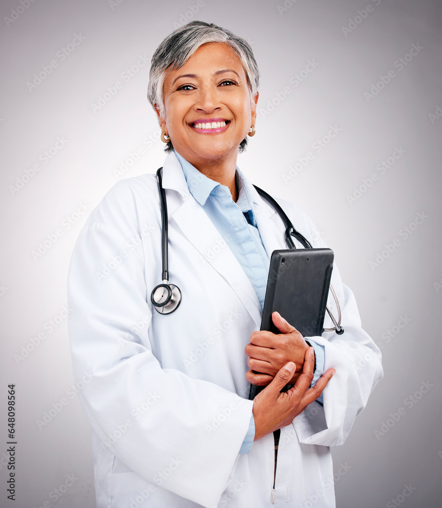 Senior, happy woman and portrait of doctor with tablet in healthcare research against a studio background. Mature female person or medical professional smile with technology for health advice or help