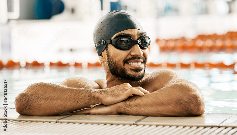 Happy, man and athlete in swimming pool after training, workout or exercise for wellness, performance or cardio fitness. Swimmer, relax and smile with sports, goggles or cap for competition and race