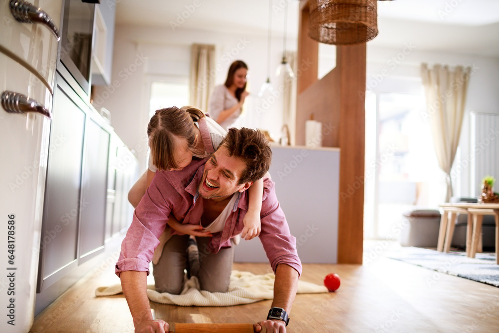 Young Caucasian father playing with his daughter at home in the living room