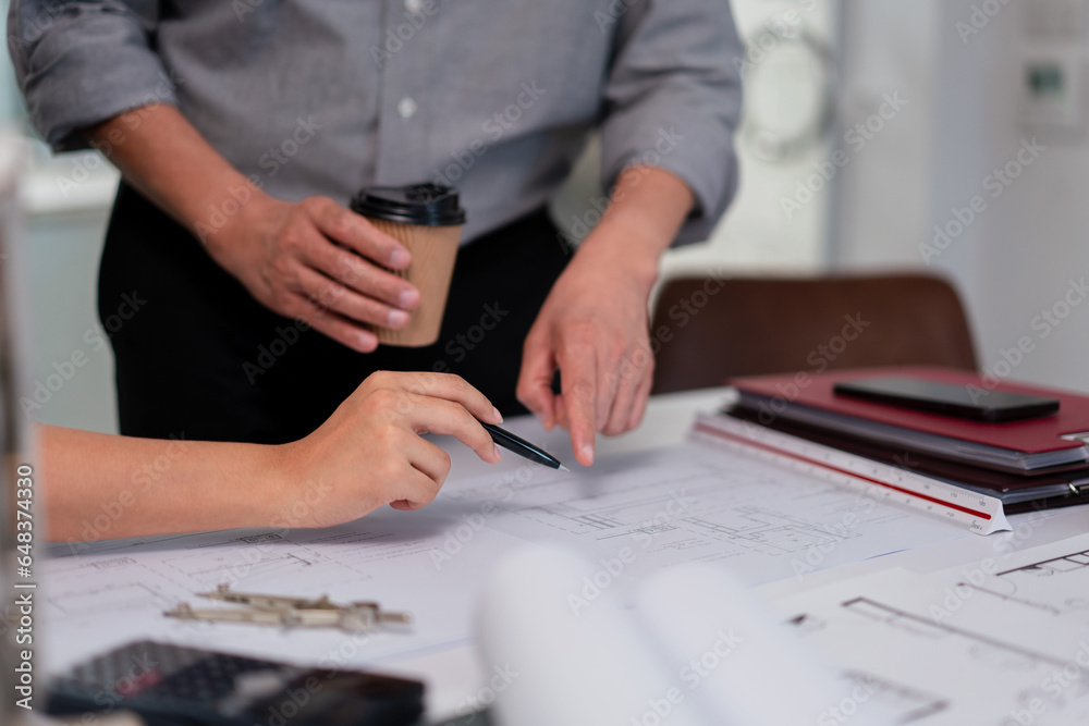 Two architects pointing on blueprint to analysis and planning about construction building project