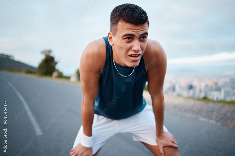 Sports, nature and man athlete breathing after running for race, marathon or competition training on mountain. Fitness, workout and young male runner on a break for an outdoor cardio exercise.